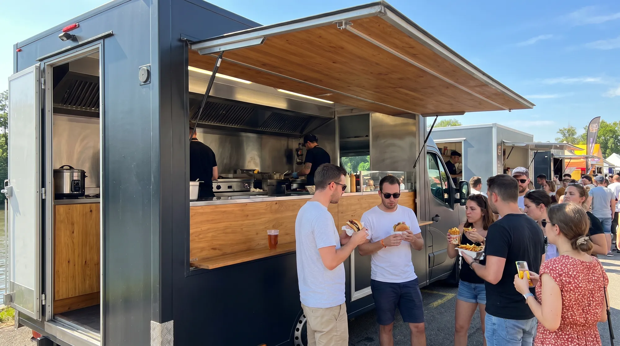 Camion burger et snack ouvert lors d'un festival d'été en Suisse, clients avec burgers