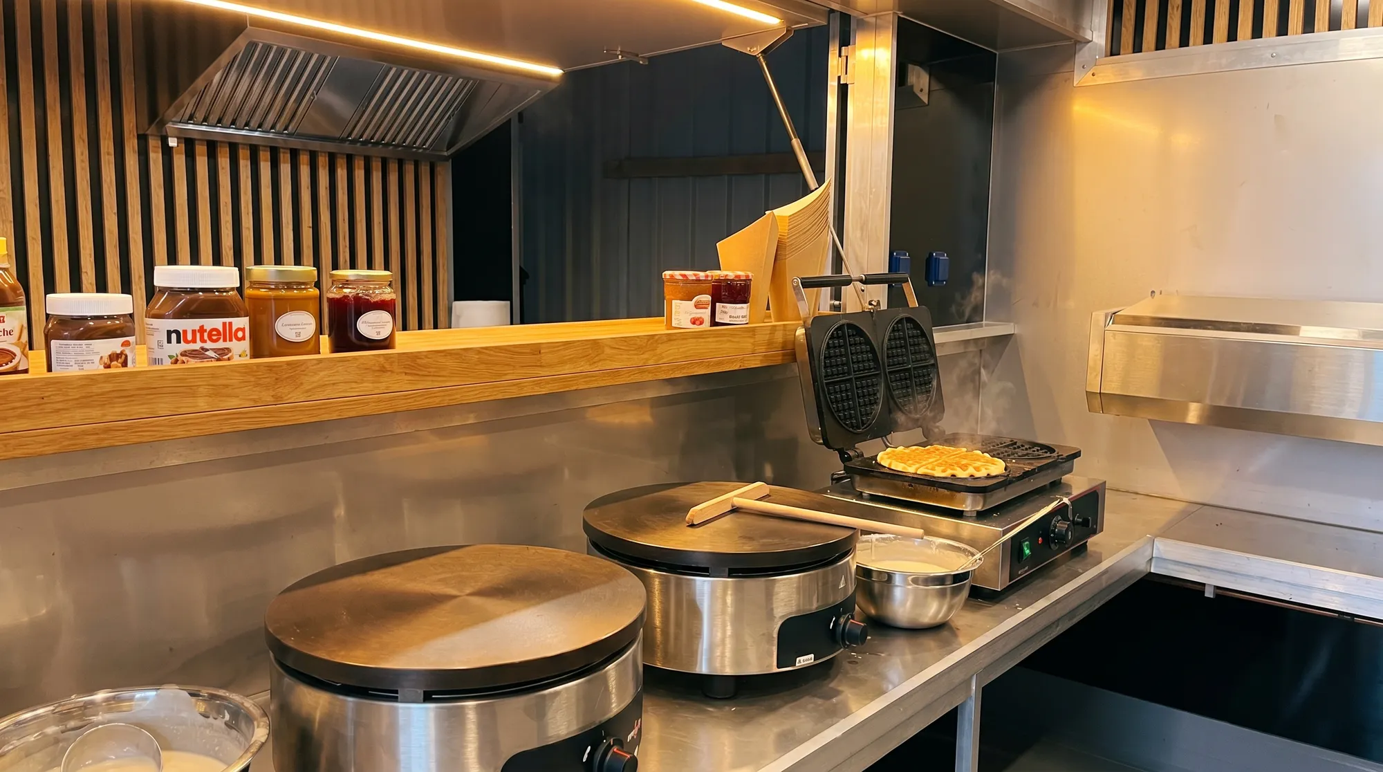 Intérieur du camion crêperie avec billigs à crêpes, gaufriers et plan de service
