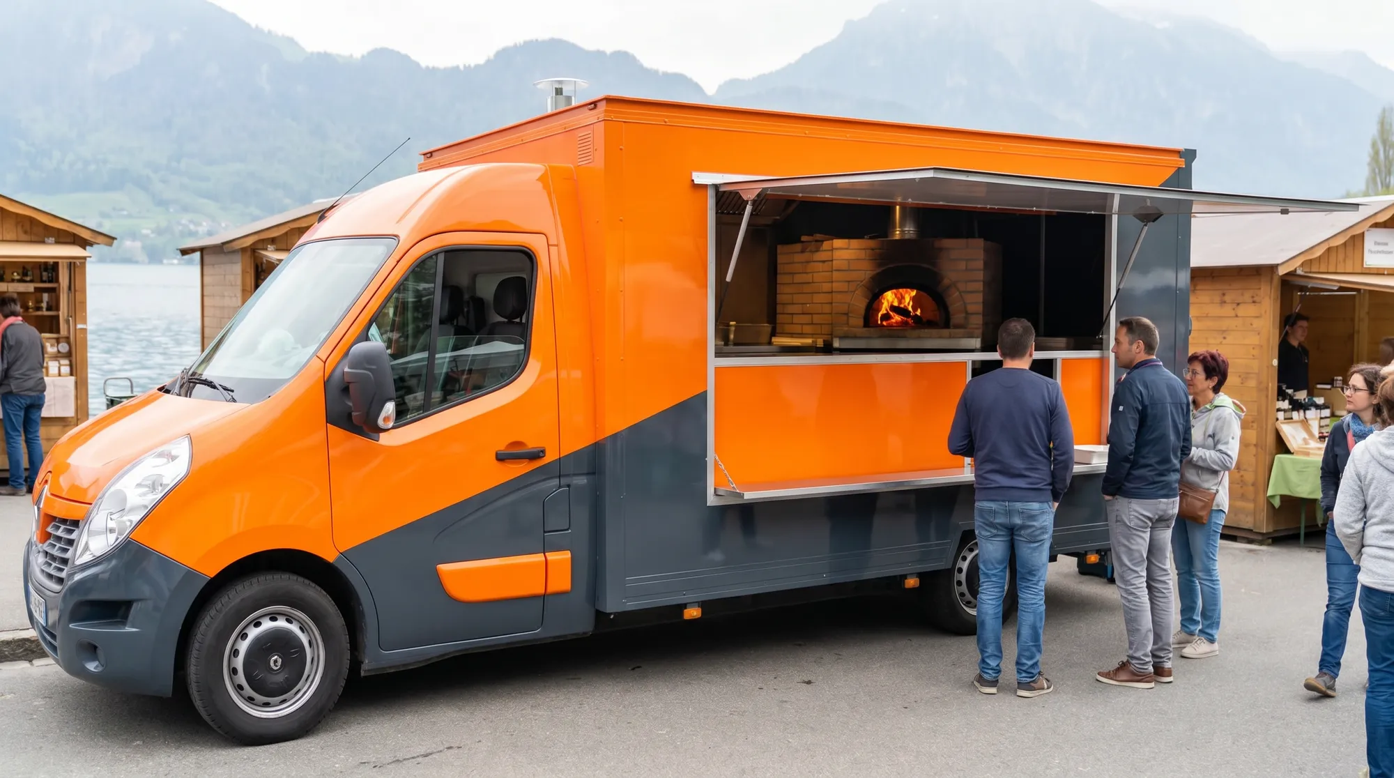 Camion pizza au feu de bois sur un marché suisse au bord d'un lac, four à pizza visible