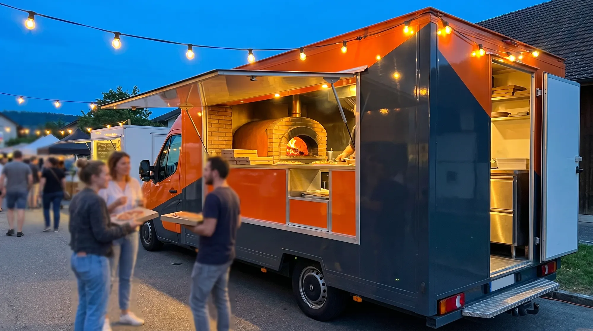 Camion pizza four à bois lors d'un événement de rue en soirée en Suisse, guirlandes lumineuses