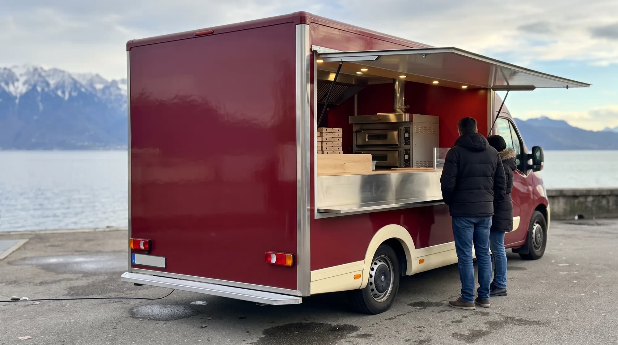 Camion pizza four à gaz vu de l'arrière au bord du lac Léman, clients au comptoir