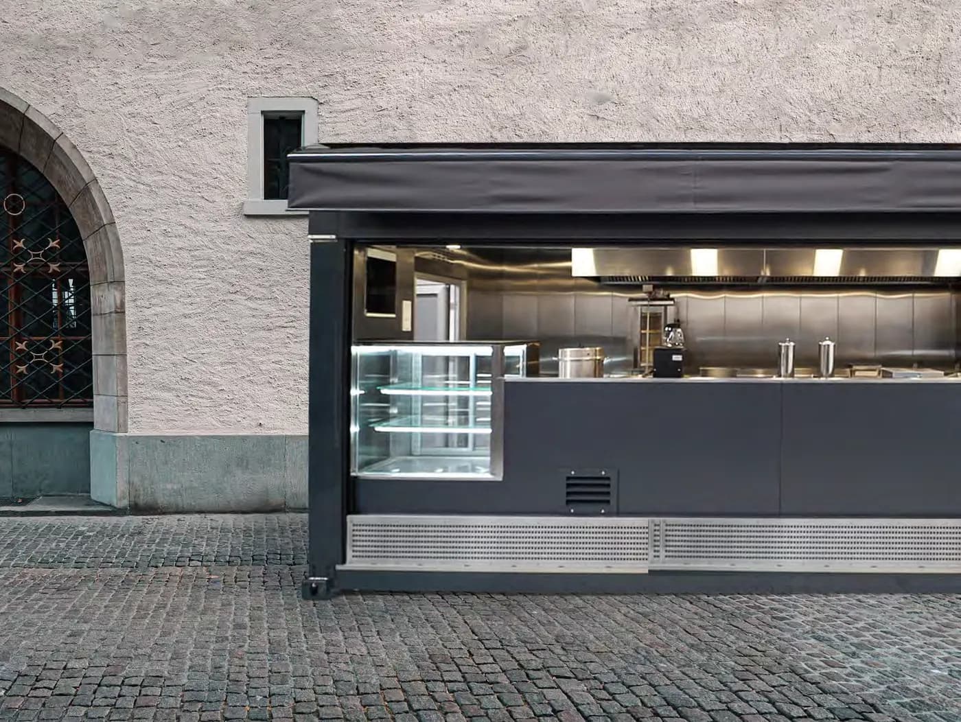 Conteneur food truck en service, auvent déployé et comptoir ouvert sur une place pavée